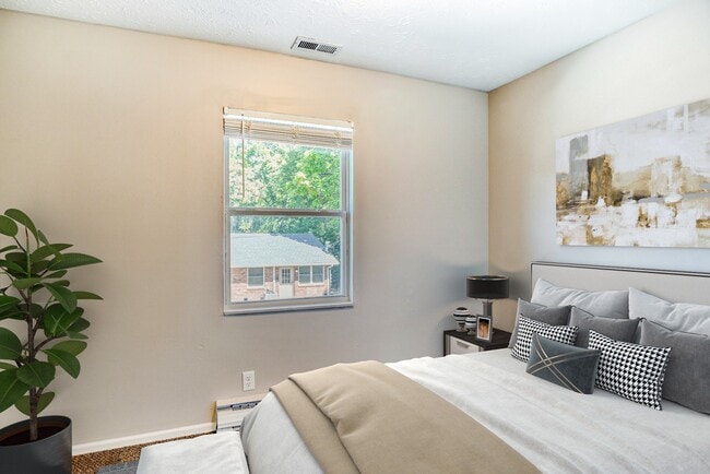 Dormitorio grande con paredes blancas. - Hillside Apartments