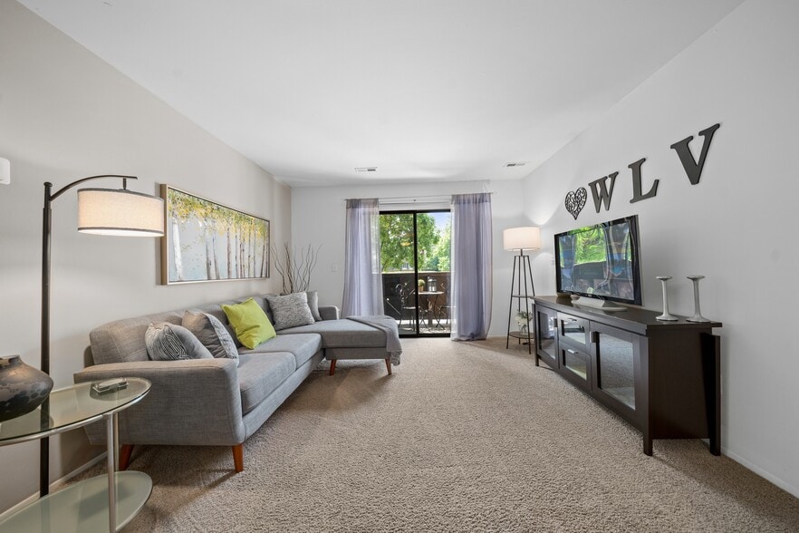 Cozy living room with natural light at Woodland Villa Apartments in Westland, MI.