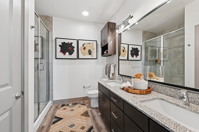Bath with espresso cabinetry, speckled granite countertops, and hard surface flooring