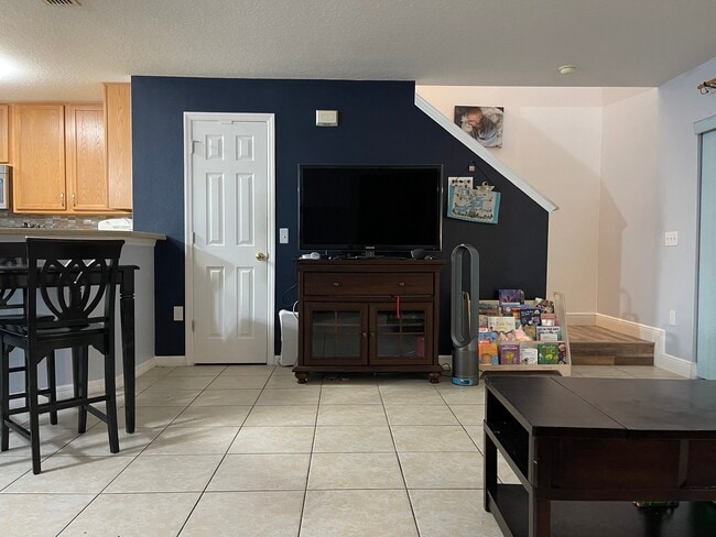 Open-concept first floor; view from wall towards stairs; bar and itchen on the left side - 2452 Hassonite St
