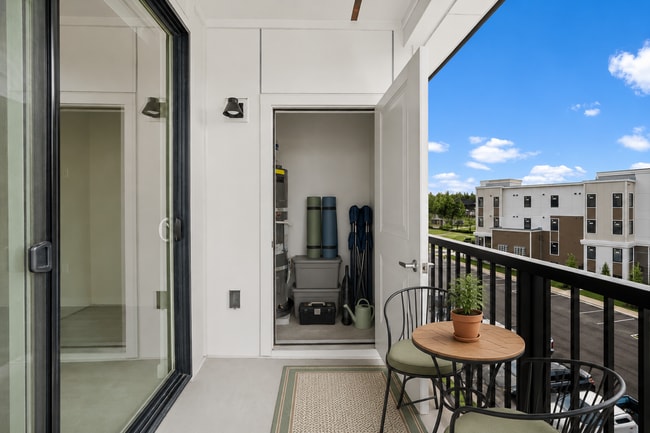 Staged balcony illustrating space for outdoor seating and organized storage
