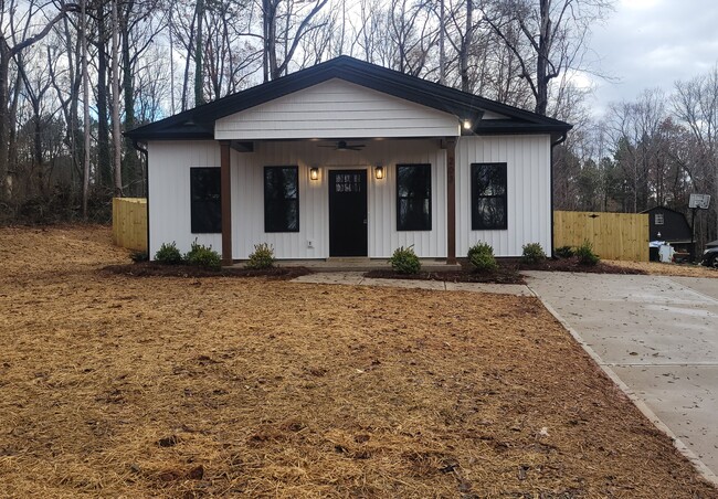 Covered front porch with ceiling fan and double car parking pad driveway - 203 Payne St Casa