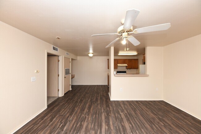 Spacious living room with hardwood-style flooring & ceiling fan