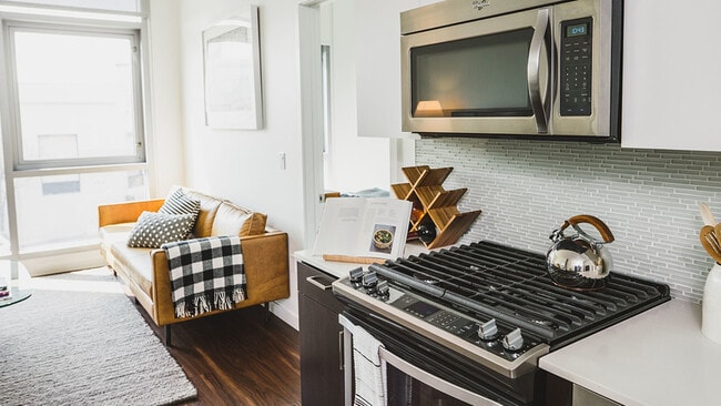 Gas cook top stove, glass tile backsplash and stainless steel appliances