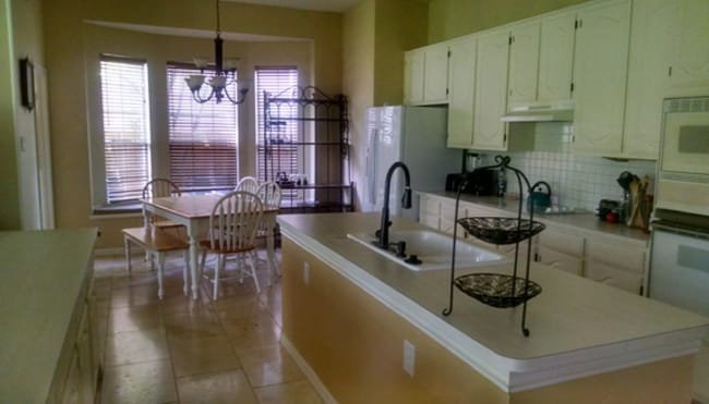 A beautifully appointed open-air kitchen with a built-in gas stove, abundant custom-style cabinetry