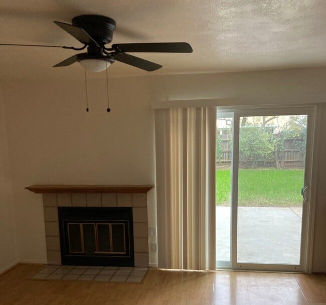 Sala familiar con chimenea y puertas corredizas de vidrio al patio. - 6744 N Warren Ave