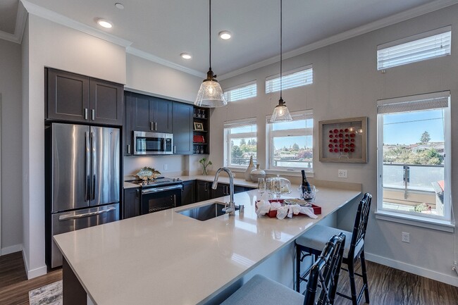 Lux Apartments offers spacious kitchens with dark walnut or arctic white cabinet finishes, stainless steel appliances, inset/undermount sinks, and quartz countertops - Lux Apartments