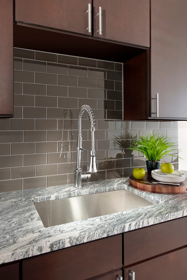 Kitchen with espresso cabinetry, granite countertop and tile backsplash