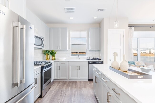 Modern Kitchen Including Quartz Countertops, Designer Tile Backsplashes & Stainless Steel Appliances including Gas Range - The Waverton Apartments