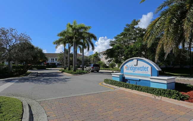 Inviting entrance to Bridgewater at Lake Osborne with palm trees and a sunny, welcoming atmosphere. - Bridgewater at Lake Osborne Rental