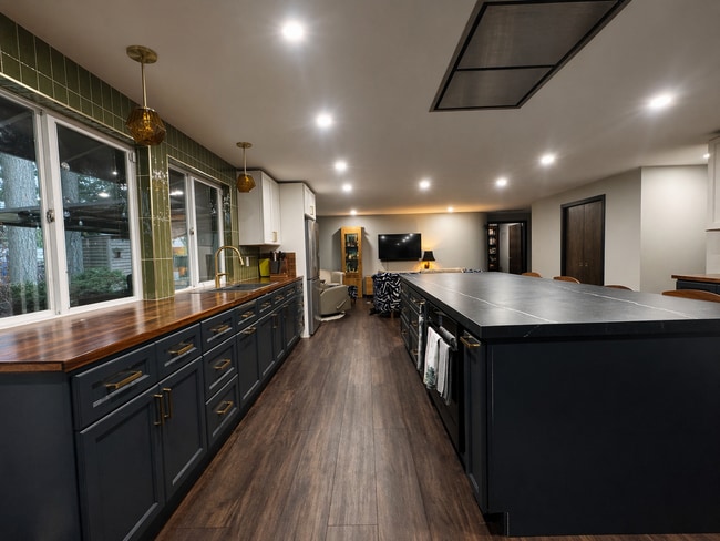 Open floor plan. Under-counter induction stove above oven in island. - 6810 Topaz Dr SW