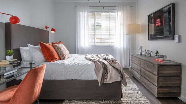 Spacious apartment bedroom with wood floors.