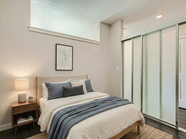 Bedroom layout featuring space for a queen bed, bedside table, and frosted sliding doors at 306 Queen Anne in Seattle.