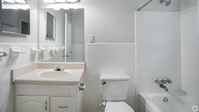 Bathroom featuring a spacious vanity, full tub, and clean tile finishes.