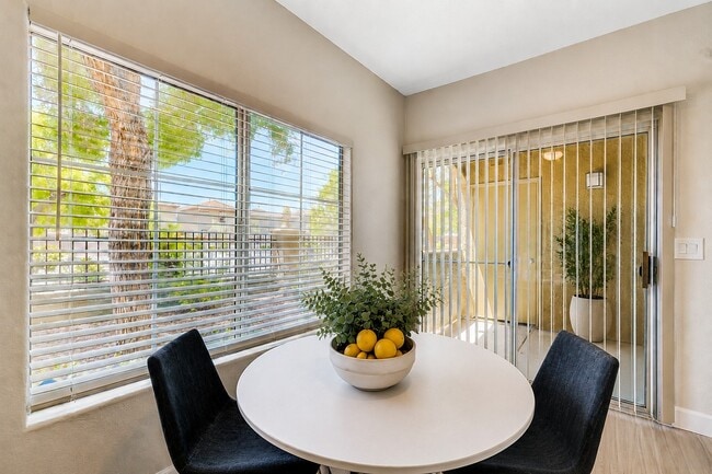 Elevate your lifestyle at Spanish Wells with this inviting dining area, showcasing abundant natural light and a serene outdoor view. Perfect for gatherings and relaxation, it seamlessly blends comfort and style. Schedule a tour today! - Spanish Wells Apartments
