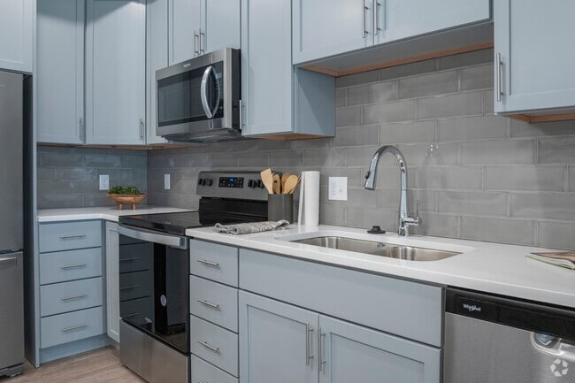 Las cocinas cuentan con encimeras de cuarzo, electrodomésticos de acero inoxidable y placas para salpicaduras de azulejos de vidrio.