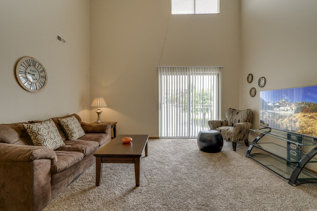 The living rooms in our loft-style homes feature soaring ceilings and natural light from large windows. - Pine Lake Heights Apartments