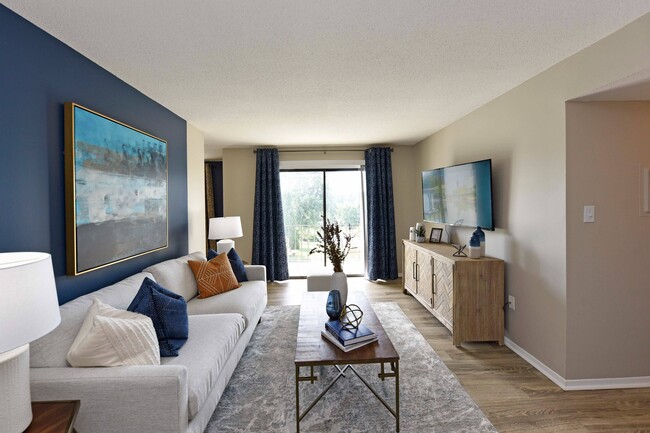 Spacious living room with hardwood-style flooring - Ivy at West Hills Apartments