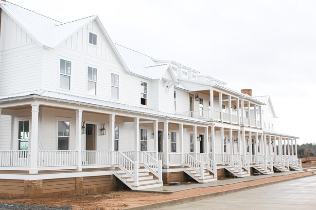 Townhome is on the far right end with the larger porch and faux chimney! - 2100 Loretta Parker Ln Townhome