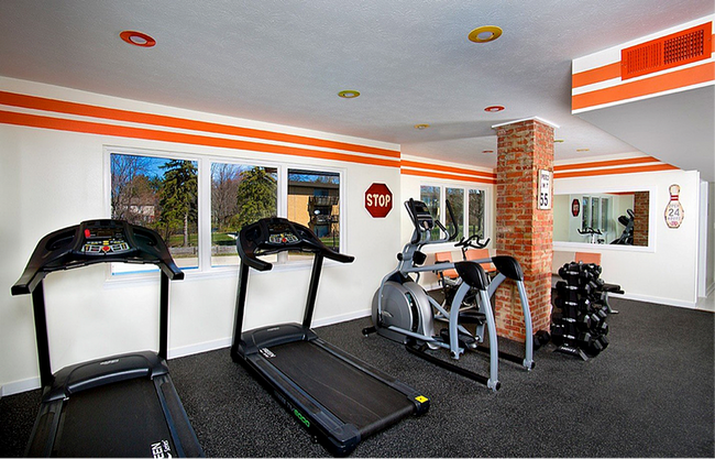 Bright and modern fitness center with treadmills, an elliptical machine, and free weights, offering a dynamic workout environment.