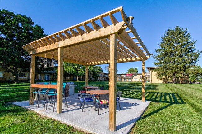 Outdoor pergola with seating and a barbecue grill, the perfect spot to entertain.