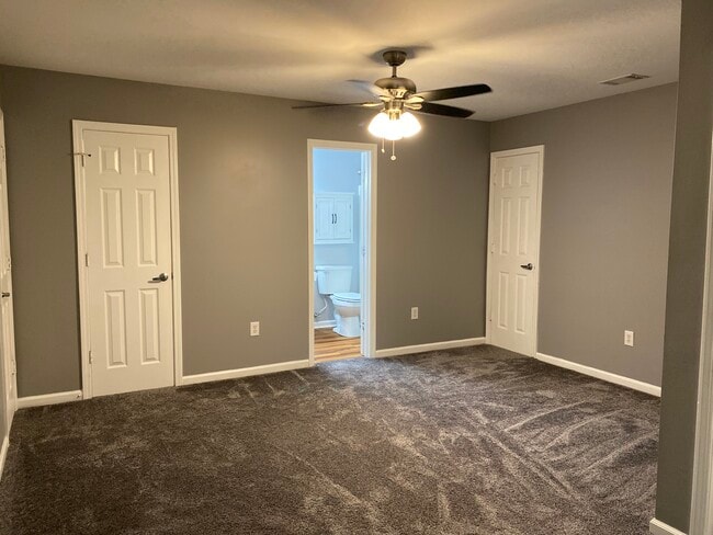 Upstairs carpeted master suite has walk in closet, full bath, ceiling fan and access to two walk in attic storage areas. - 1305 Cedar Shoals Drive #500