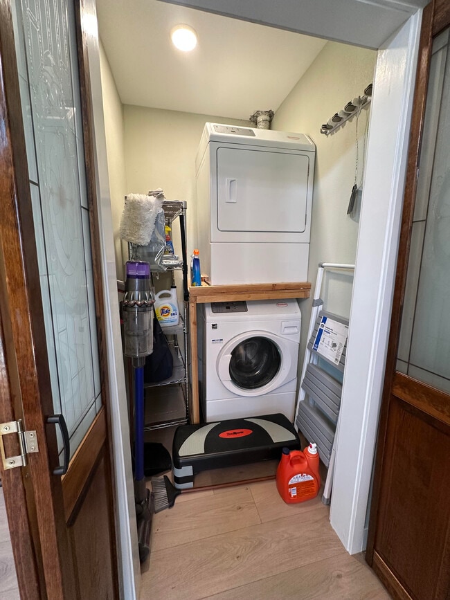 Full-sized stacked washer and dryer behind wooden doors - 1490 Ash St Unit Furnished Napa ADU  B