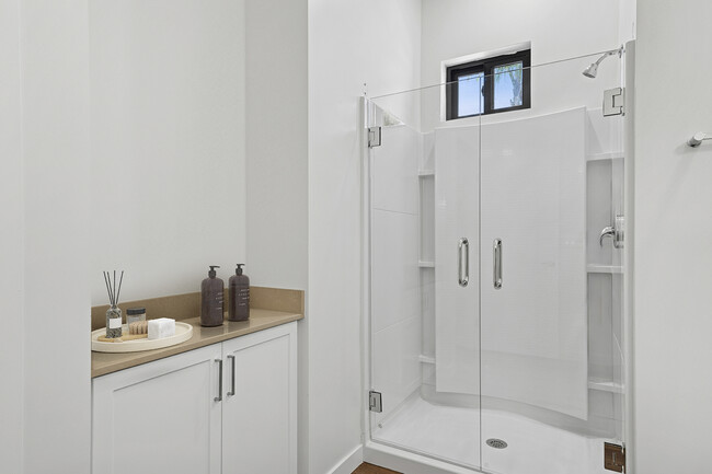 Freestanding Home bath with beige quartz countertop and white cabinetry