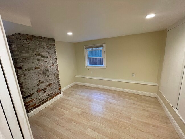 Bedroom with charming brick accent wall - 1534 Benton St Unit A