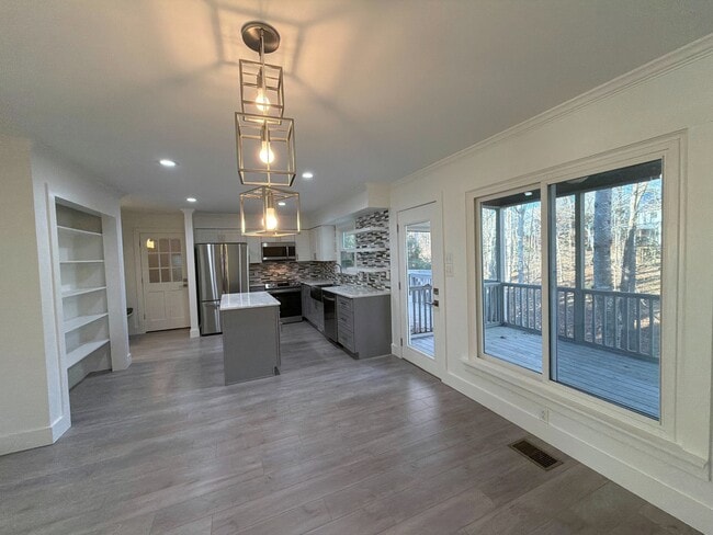 Dining room to kitchen to GIANT windows to incredible screened-in porch. - 115 Waterfall Ct