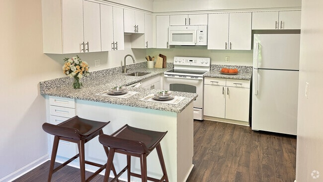 Large gourmet kitchen with bistro bar, granite countertops, uplevel appliances and luxe plank flooring. - Covington Club Luxury Homes