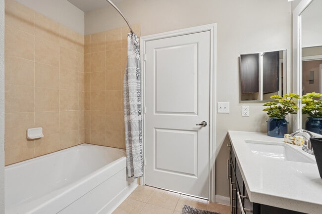 Bath with dark cabinetry, white quartz countertops, and hard surface flooring