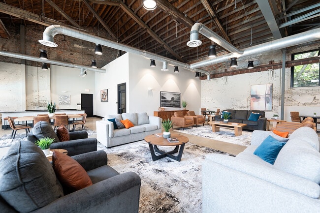Modern loft-style dining and kitchen area with exposed brick
