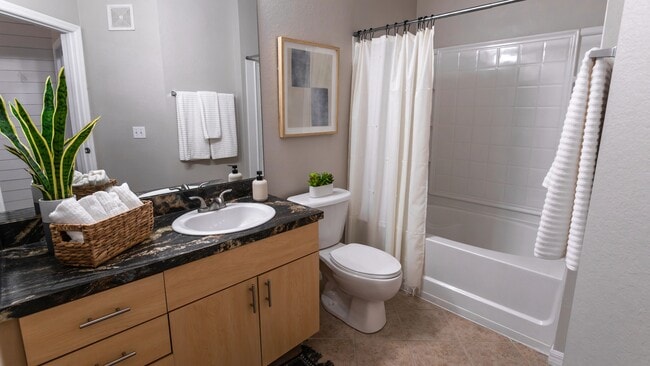 Enjoy a beautifully designed bathroom featuring modern finishes, a large mirror, and sleek countertops.