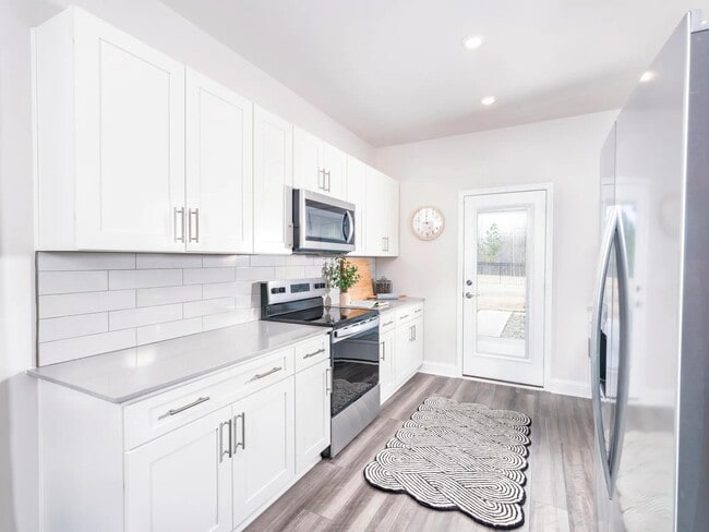 Creating culinary magic in this spacious kitchen complete with stainless steel appliances.