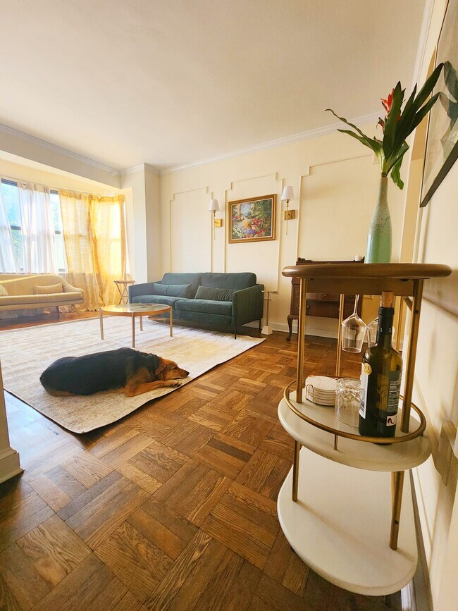 Sun soaked living room w/ sweeping bay windows and tasteful mid-century furnishings! - 2515 K St NW Unidad 504