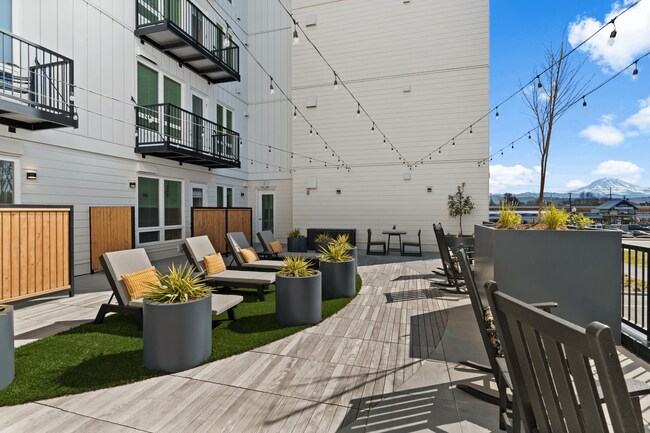 Enjoy fresh air and mountain views from a beautifully designed outdoor lounge in Sumner apartments.