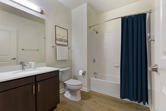 Renovated Package I bath with white quartz countertop, espresso cabinetry, and hard surface flooring