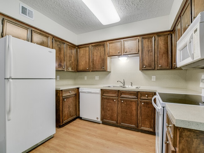 Practical galley kitchen equipped with full-sized appliances and generous cabinet storage.