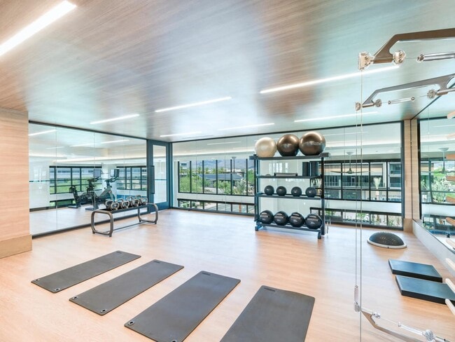Stretch, lift, or flow in the light-filled fitness studio featuring yoga mats, weights, and floor-to-ceiling mirrors.
