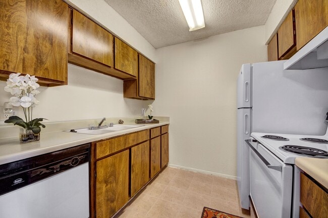 A kitchen with overhead lighting, lots of cabinet space, and a dishwasher - The Bradford Apartments