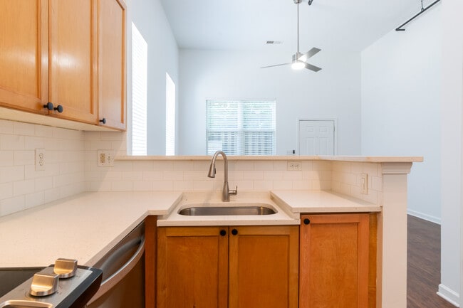 Beautifu kitchen with stone countertops, updated appliances, subway tile backsplash, and bar seating