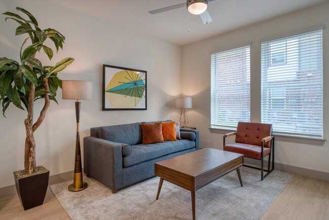 Inviting Oakwood Trails - A 62+ Commuity in Spring, TX living room with open layout, large windows for natural light, and durable plank flooring.