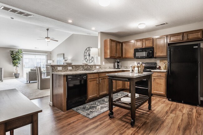 Step into a stylish, functional kitchen featuring a central island, sleek black appliances, and warm wooden cabinetry—perfect for cooking and entertaining.