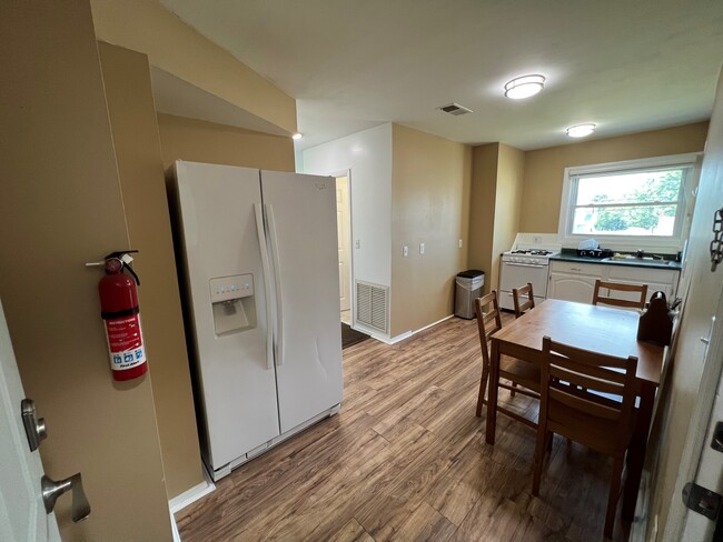 Kitchen with full size refrigerator and dining table - 100 Manning Pl Apartments