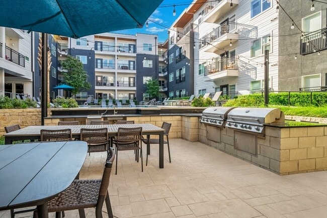 Parrilla en el lugar con mesas y asientos para comer - Larq Henderson