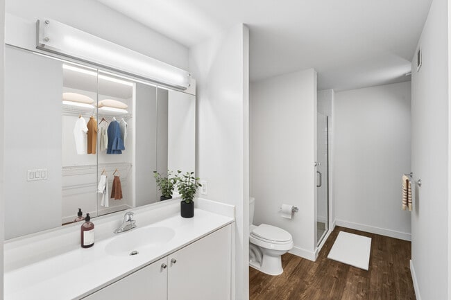 Bath with white cabinetry, white quartz countertops, and hard surface flooring - AVA High Line