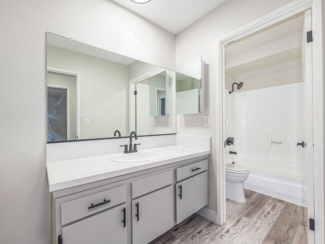 Mueble de baño de estilo moderno con vista al baño completo.