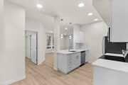 Modern staged kitchen featuring bright white storage, stainless appliances, and a sleek quartz-style island.