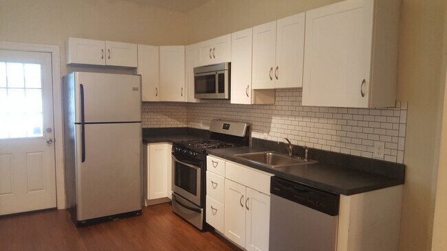 Kitchen with stainless steel appliances and subway tile backsplash - 125 s 8th st